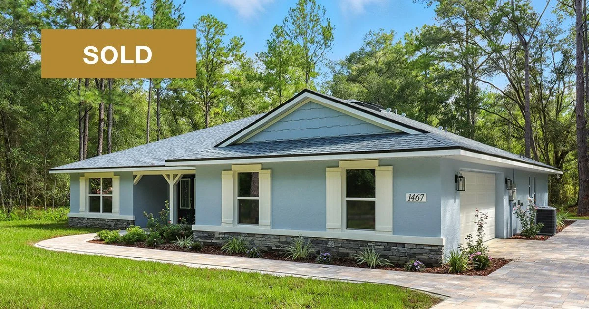 Exterior of a newly constructed home on a wooded lot with large pine trees 