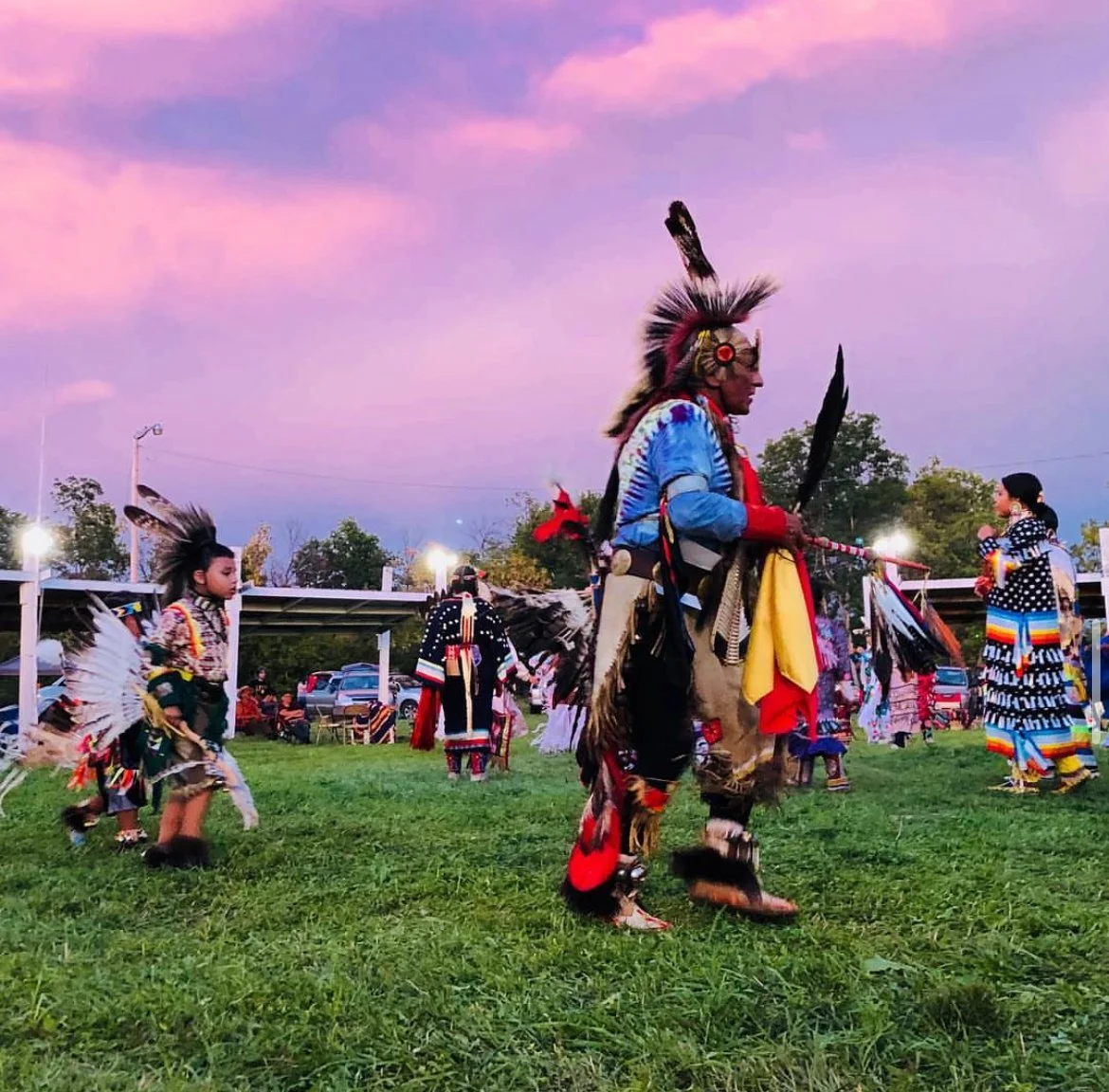 Powwow dancers dancing in an arbor