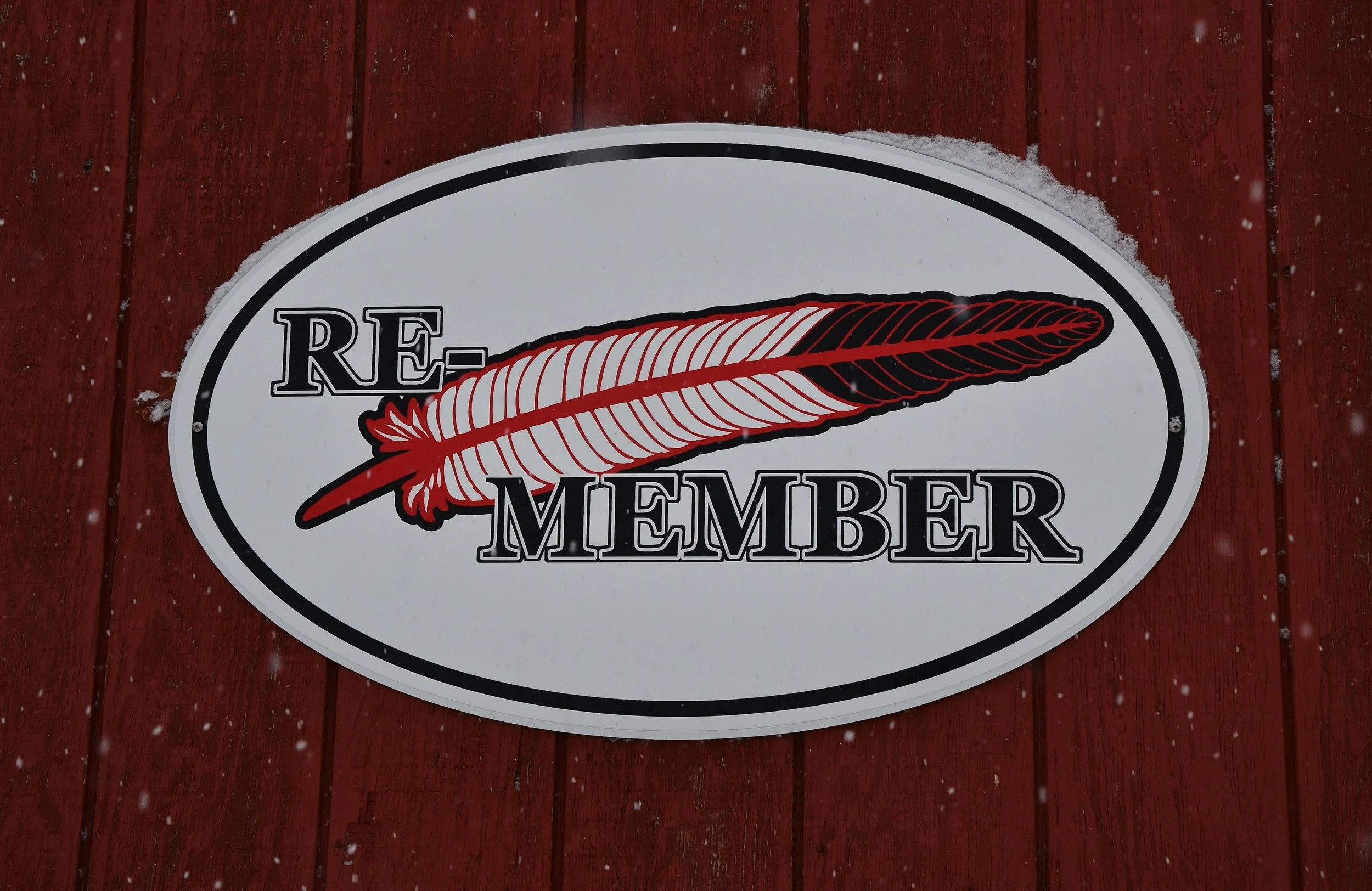 A sign in a snowy setting that reads "Re-Member"