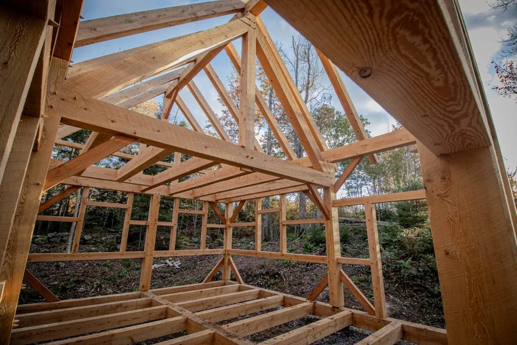 Wooden timber frame under construction in a forest setting