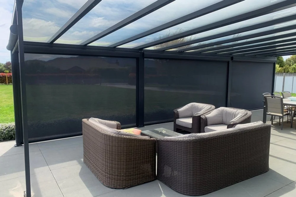 Outdoor seating area sheltered by ziptrak blind and flexiroof.