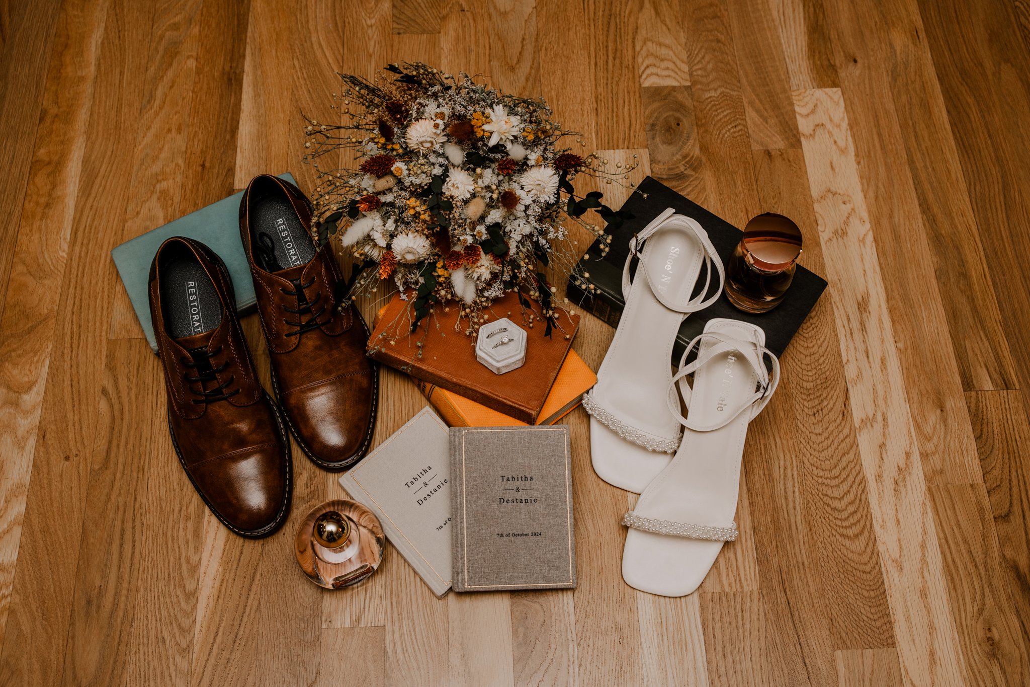 Elopement details flat lay featuring vow books, wedding rings, shoes, and bouquet for Garden of the Gods elopement in Colorado Springs.