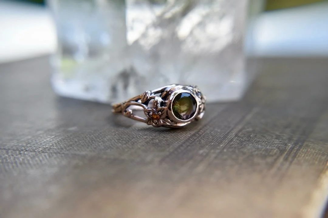 I&rsquo;m so glad I finally get to share this custom ring I just finished! I made it in 14k rose gold with a tri-color tourmaline, orange garnets, and little Trillium flowers.