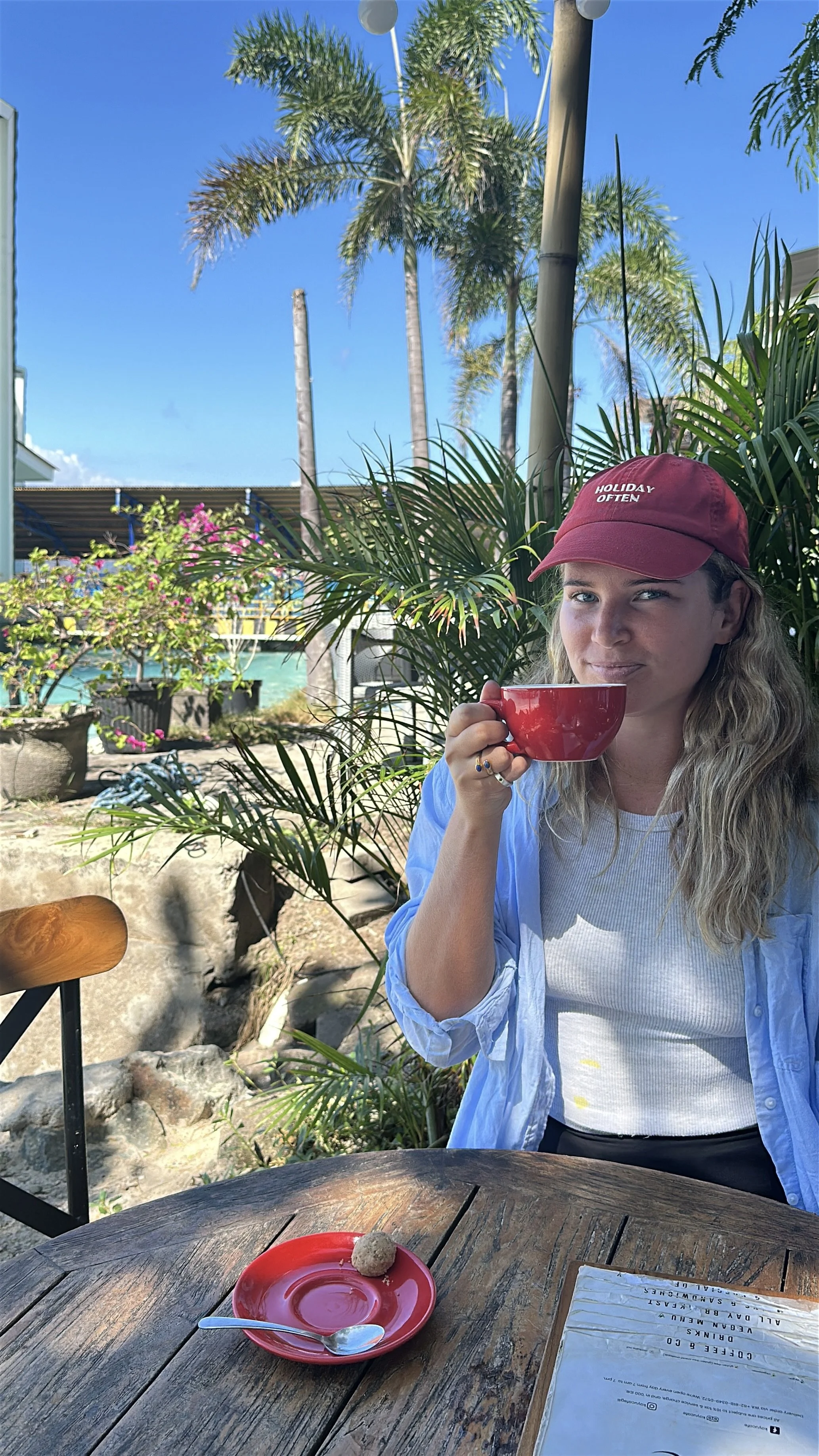 Hannah sitting on an island in Bali enjoying a Freedom Business lifestyle and working remotely.