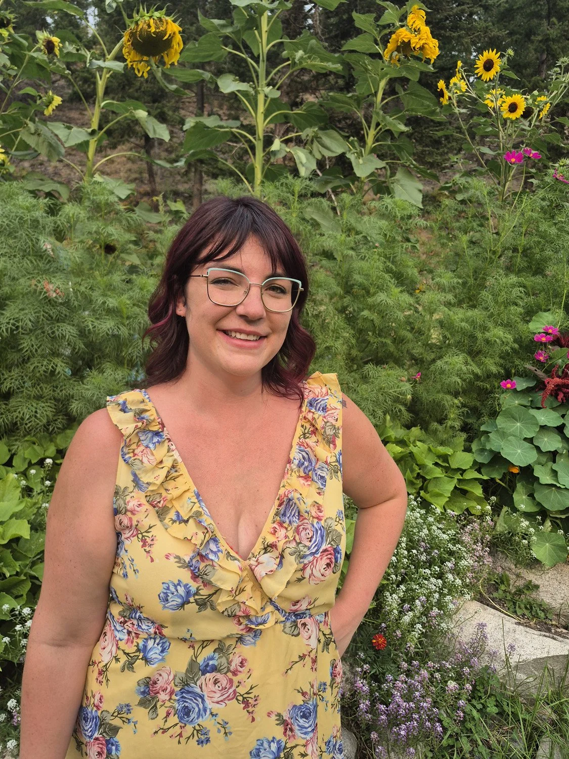 Jasmine, senior hair stylist at Beauty Box, smiles in an Okanagan sunflower garden.