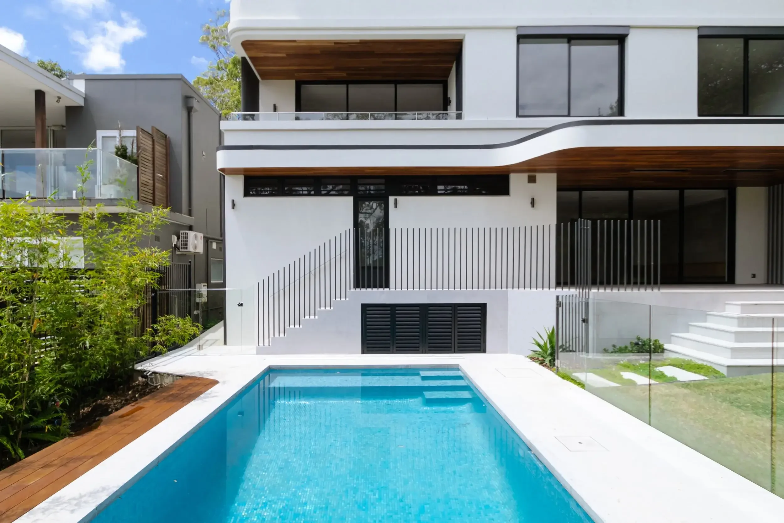 Outdoor space with seating area and green lawn with a pool near a modern home
