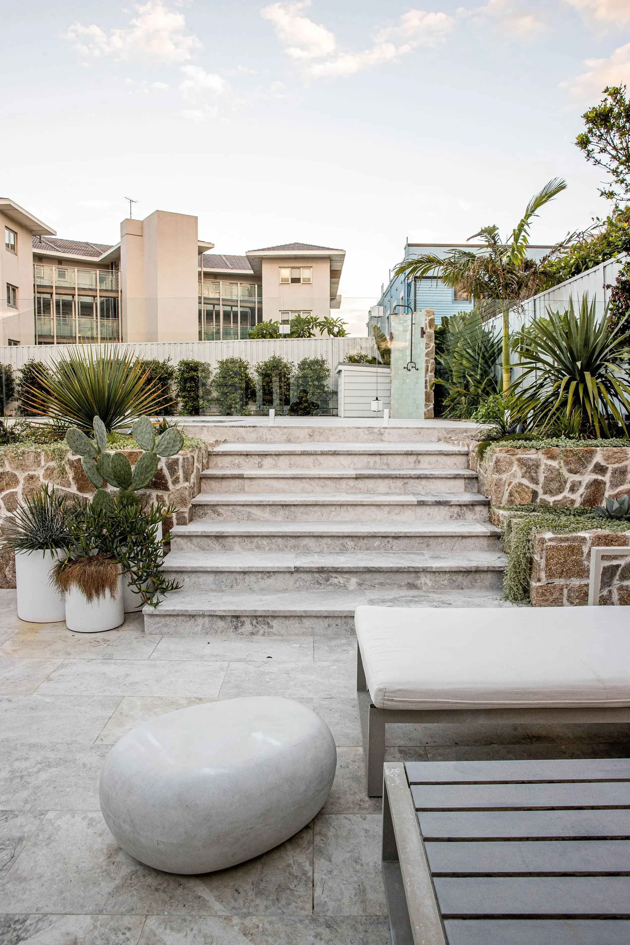 Outdoor landscaped patio with stone paving and lush green plants