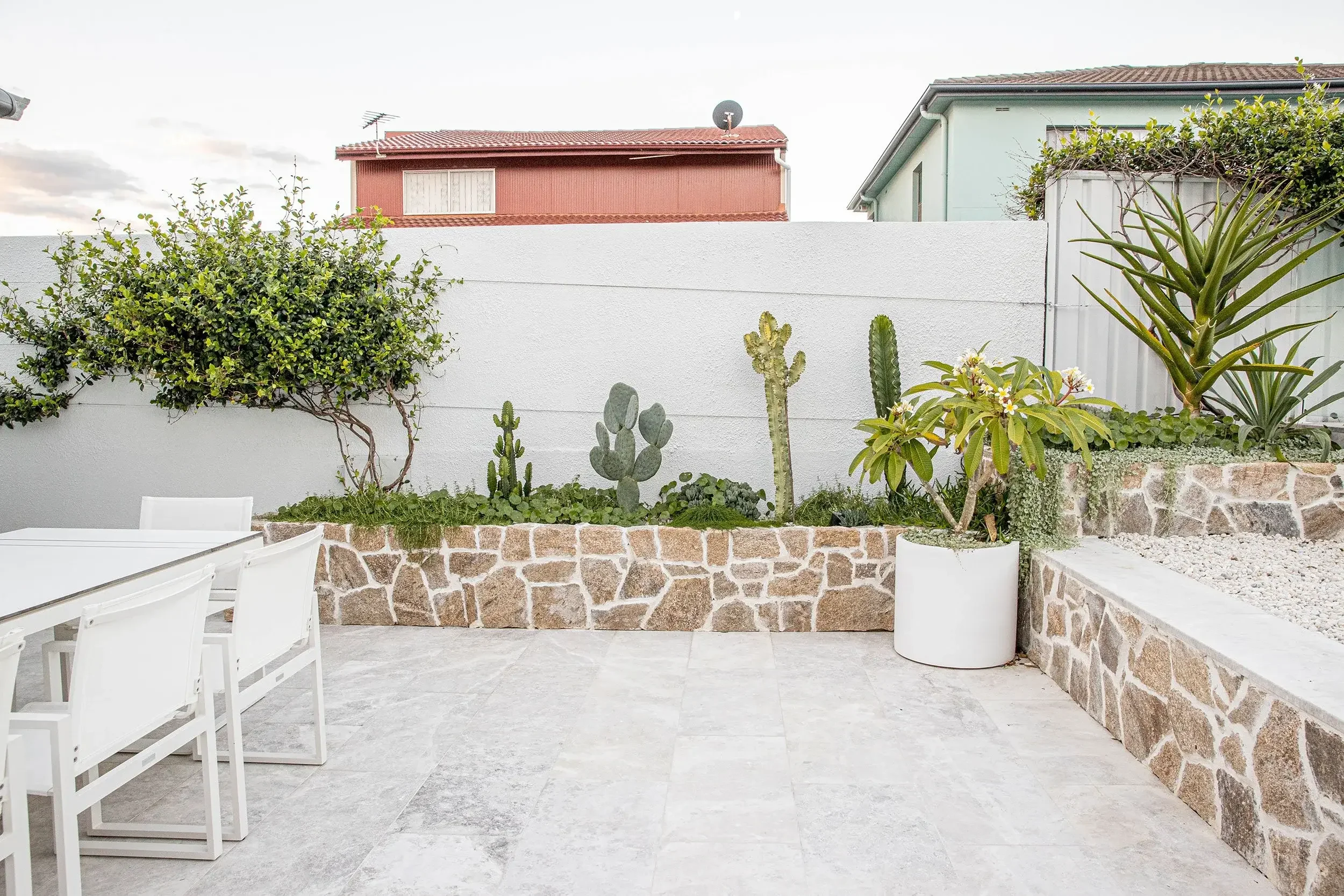 Backyard patio with stone paving and surrounding green plants