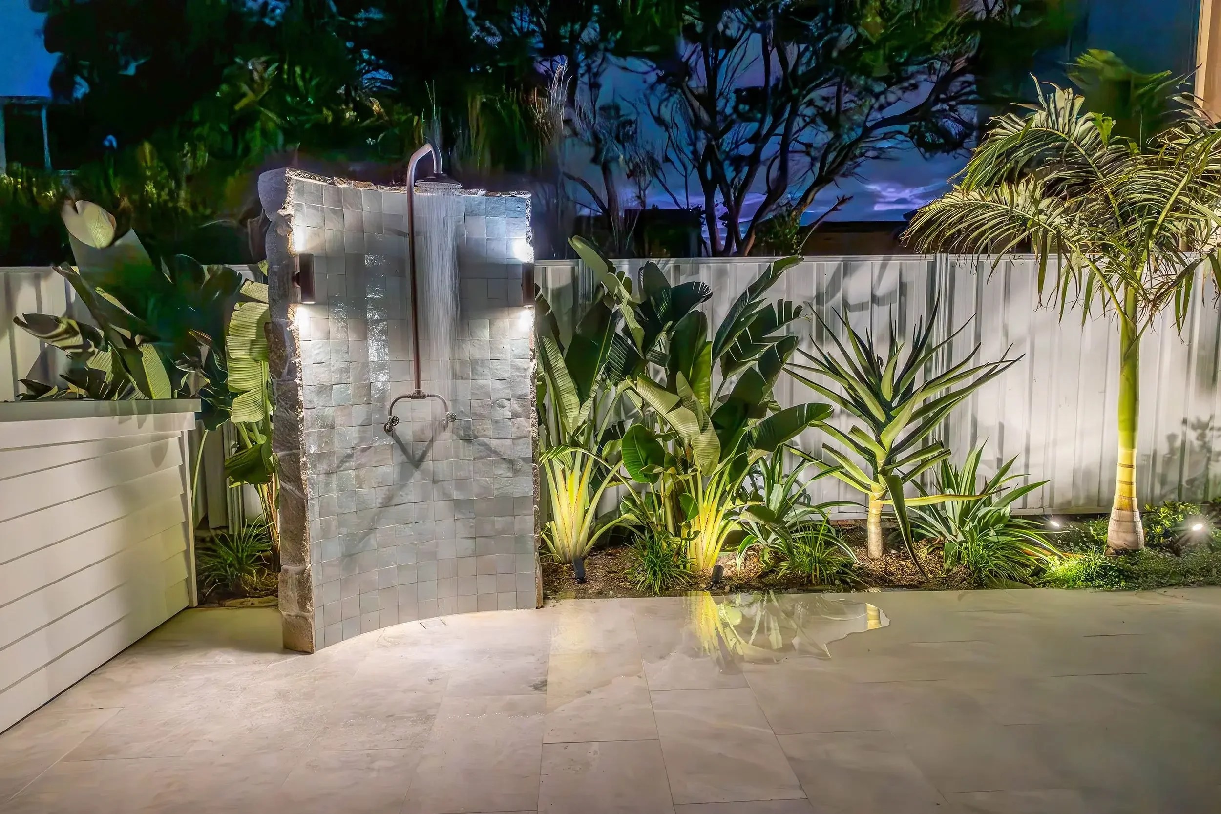 Outdoor landscaped patio area with stone paving and lush green plants