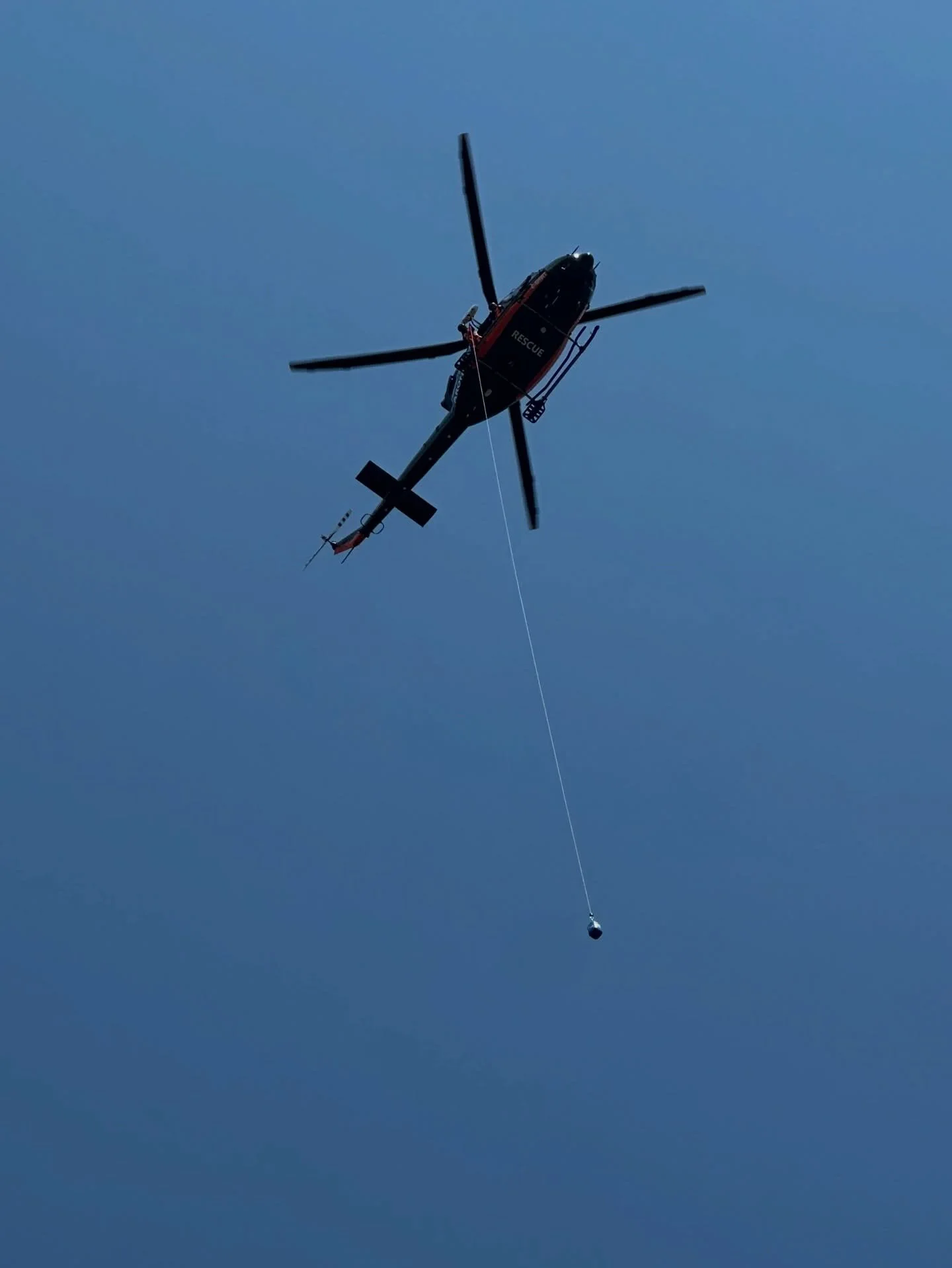 Behind every rescue is hundreds of volunteer hours of training and administration. This photo captures a recent winch operator exam, with the RO and Pilot conducting a static line procedure with a weight. This is how we maintain constant readiness fo