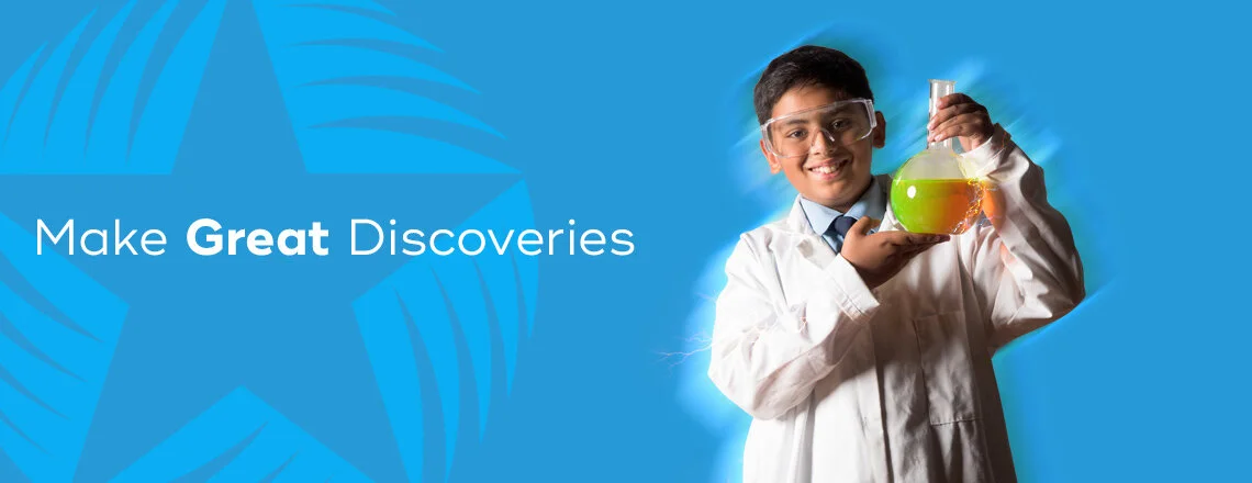 Young boy in a lab coat and safety glasses holding a flask of colorful liquid, smiling, with a blue background and the text 'Make Great Discoveries'.