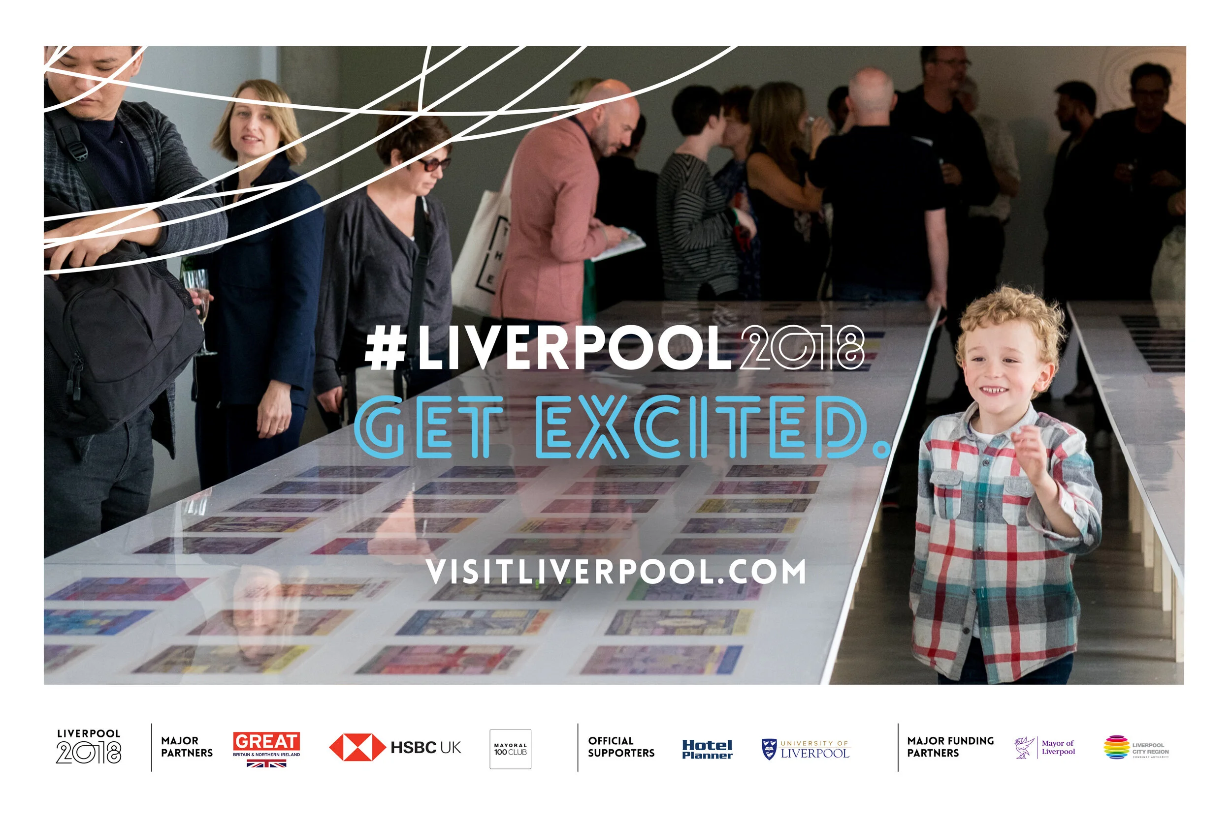 People gathered around a table with artwork displayed; a young boy with curly blonde hair smiling in front. Overlay text promotes Liverpool 2018 event with the slogan Qualification: 'Get Excited' and website visitliverpool.com.