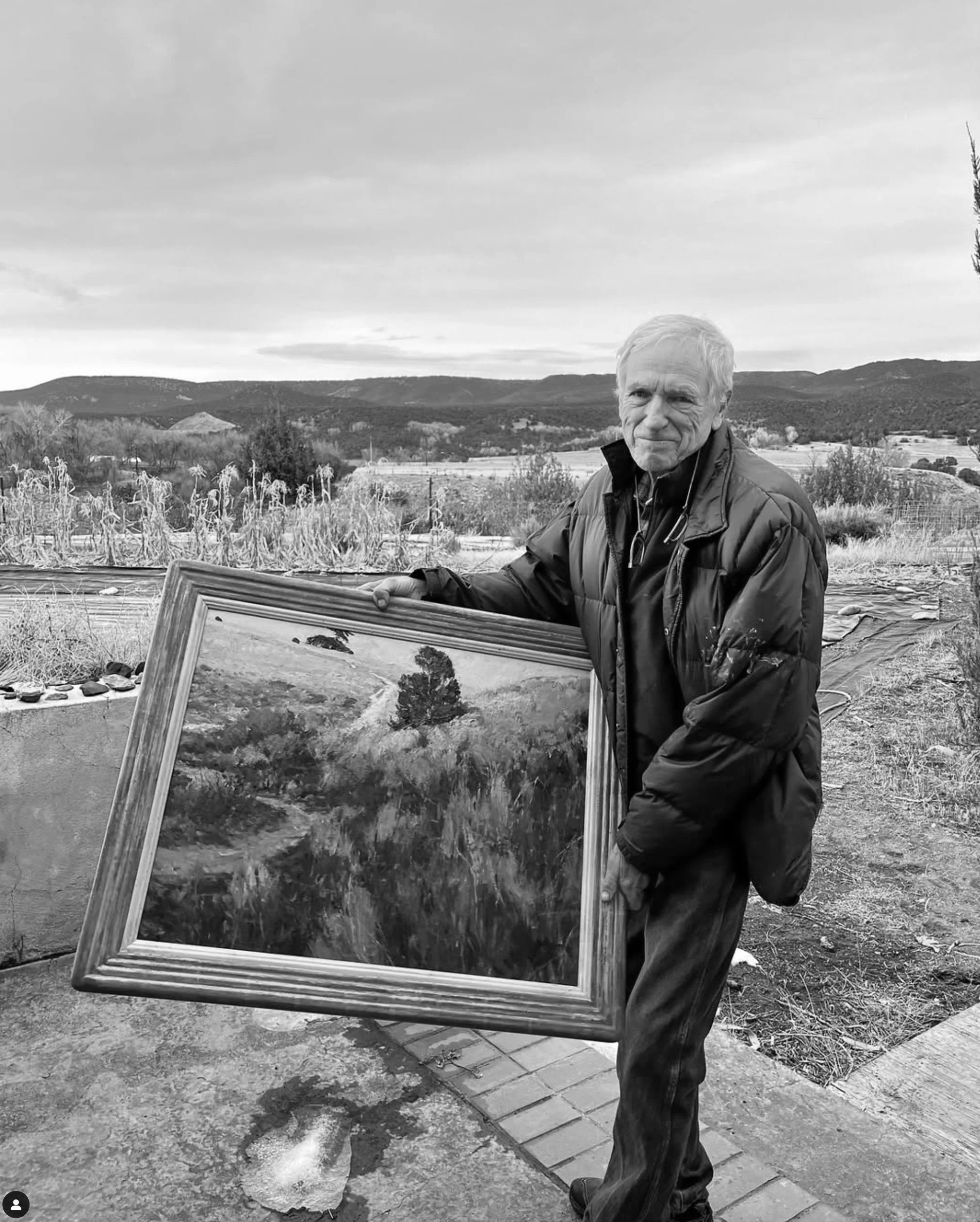 Artist Len Chmiel holding his painting Trail to the View (2024).