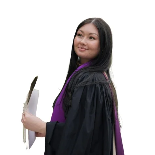 Young woman in a graduation gown holding a diploma and smiling.