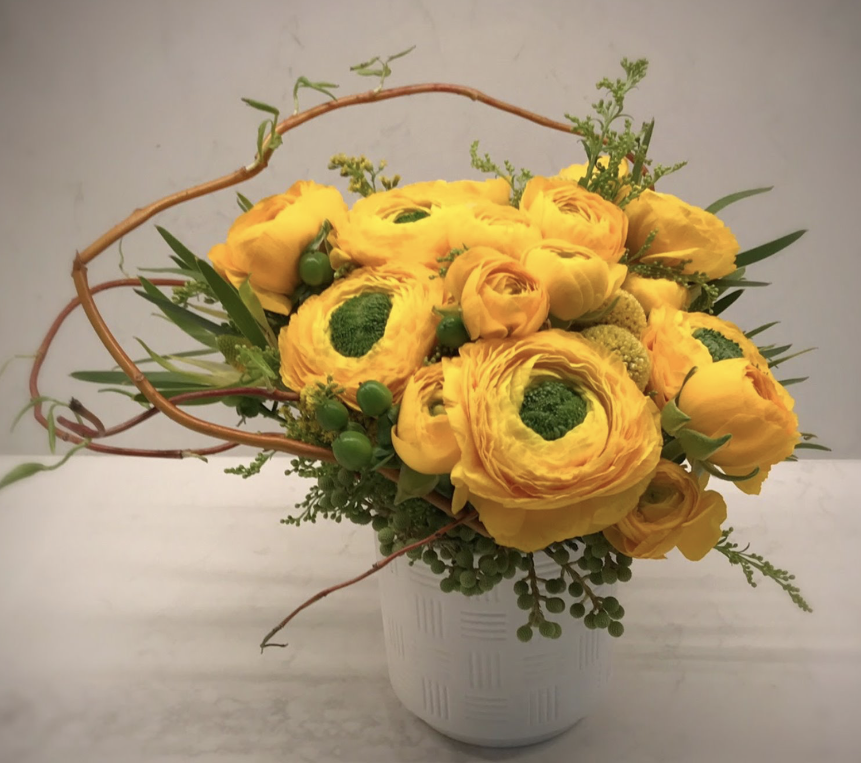 Giant Cloni Ranunculus, Cloony Ranunculus, Leucadendron, Aster Solidago, Willow Branch, Brunia, Craspedia, and Hypericum Berries