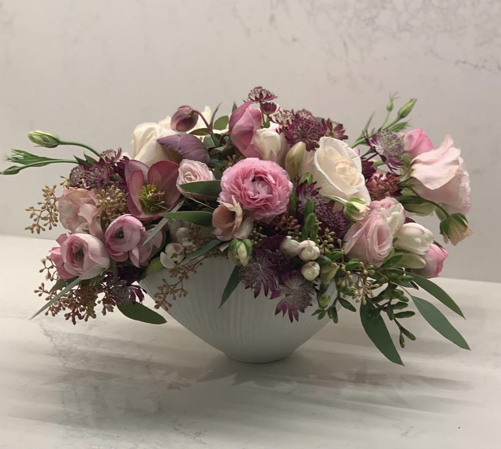 Seeded Eucalyptus, Lisianthus, Hellebores, Olea Branch, Astrantia, Rose, Freesia, and Cloony Ranunculus