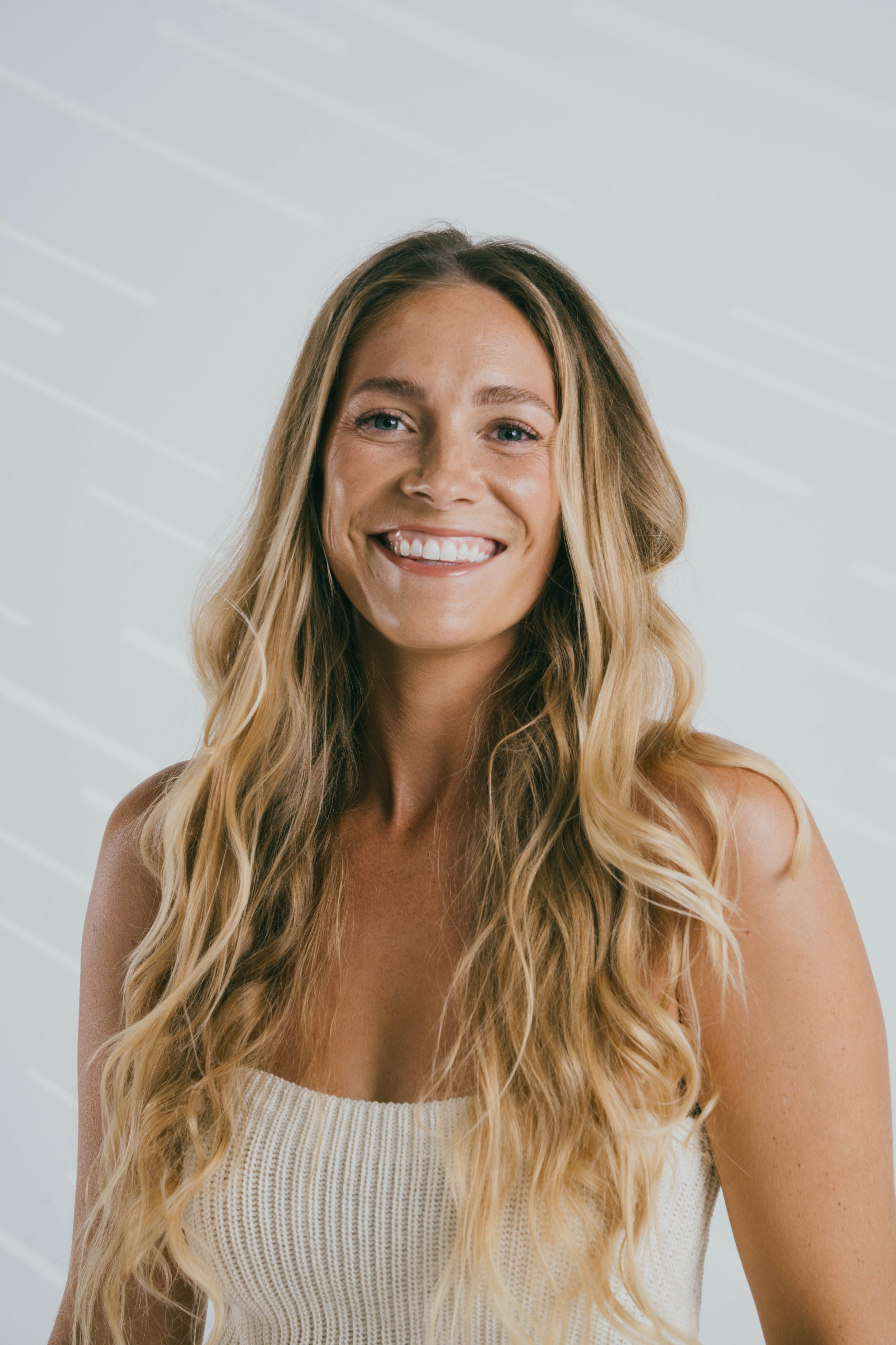 Beauty portrait of model Megan Koval smiling in soft studio light.