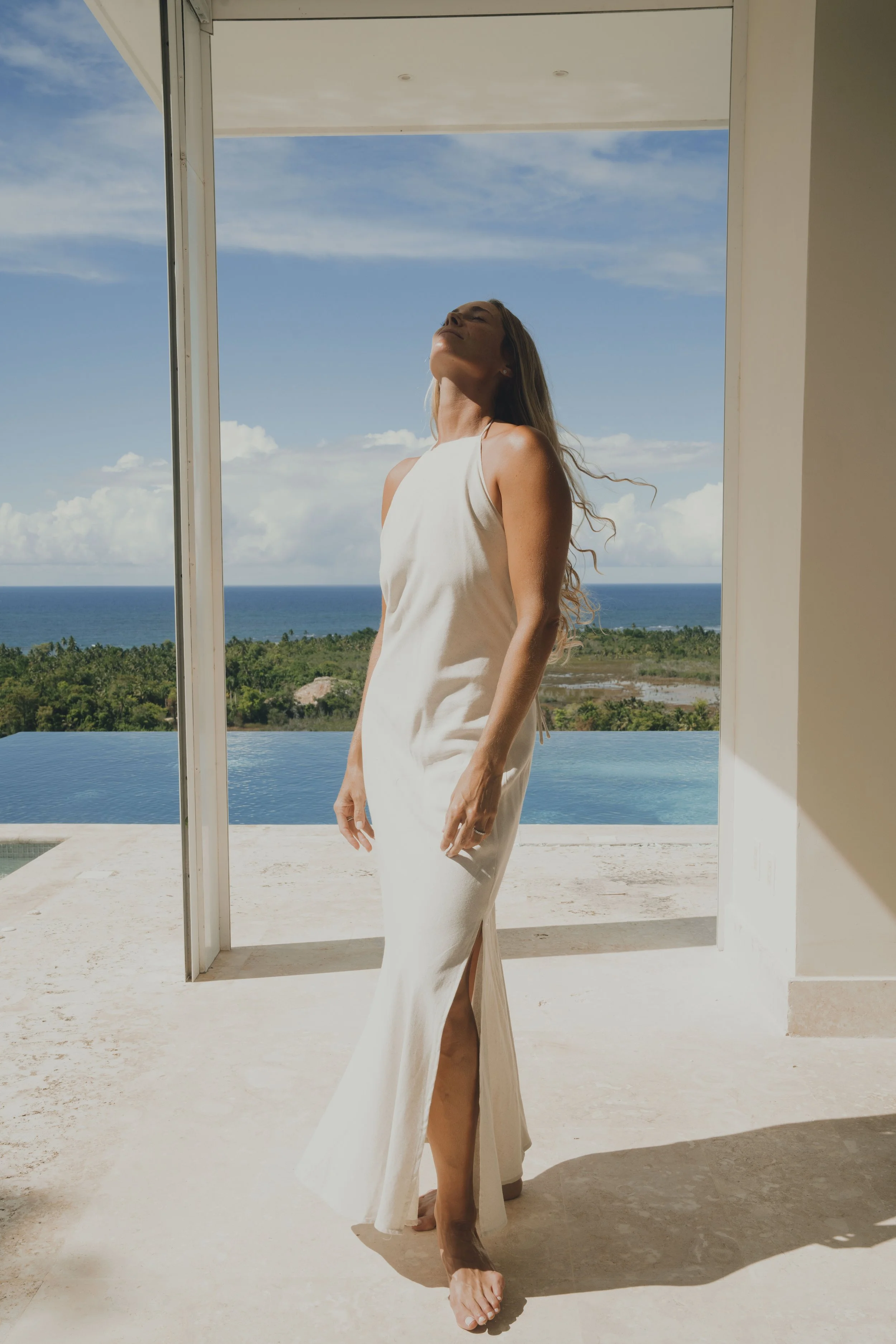 Lifestyle model standing in a luxury beachfront villa, natural resort and travel lifestyle scene.