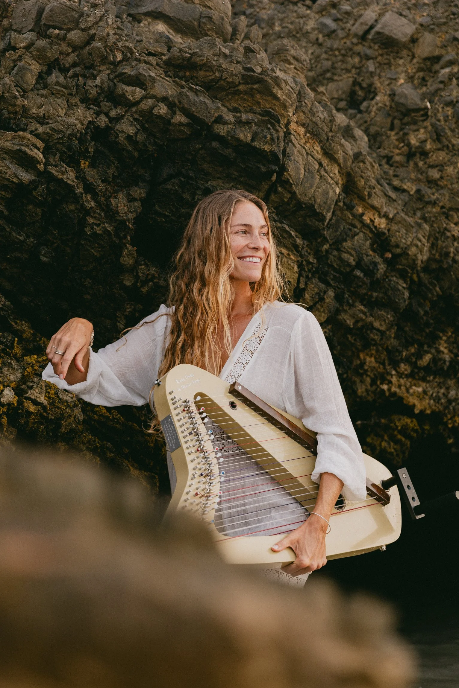 Natural lifestyle portrait of a harpist by the ocean.