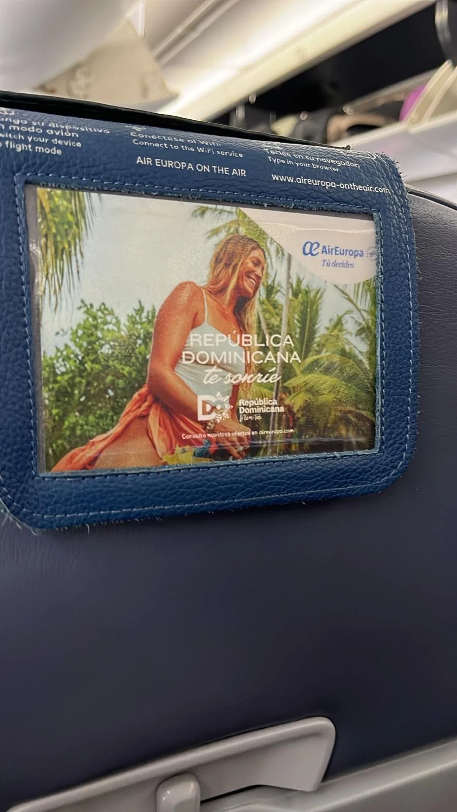 Tourism campaign featuring model Megan Koval displayed on Air Europa airplane seat postcards.