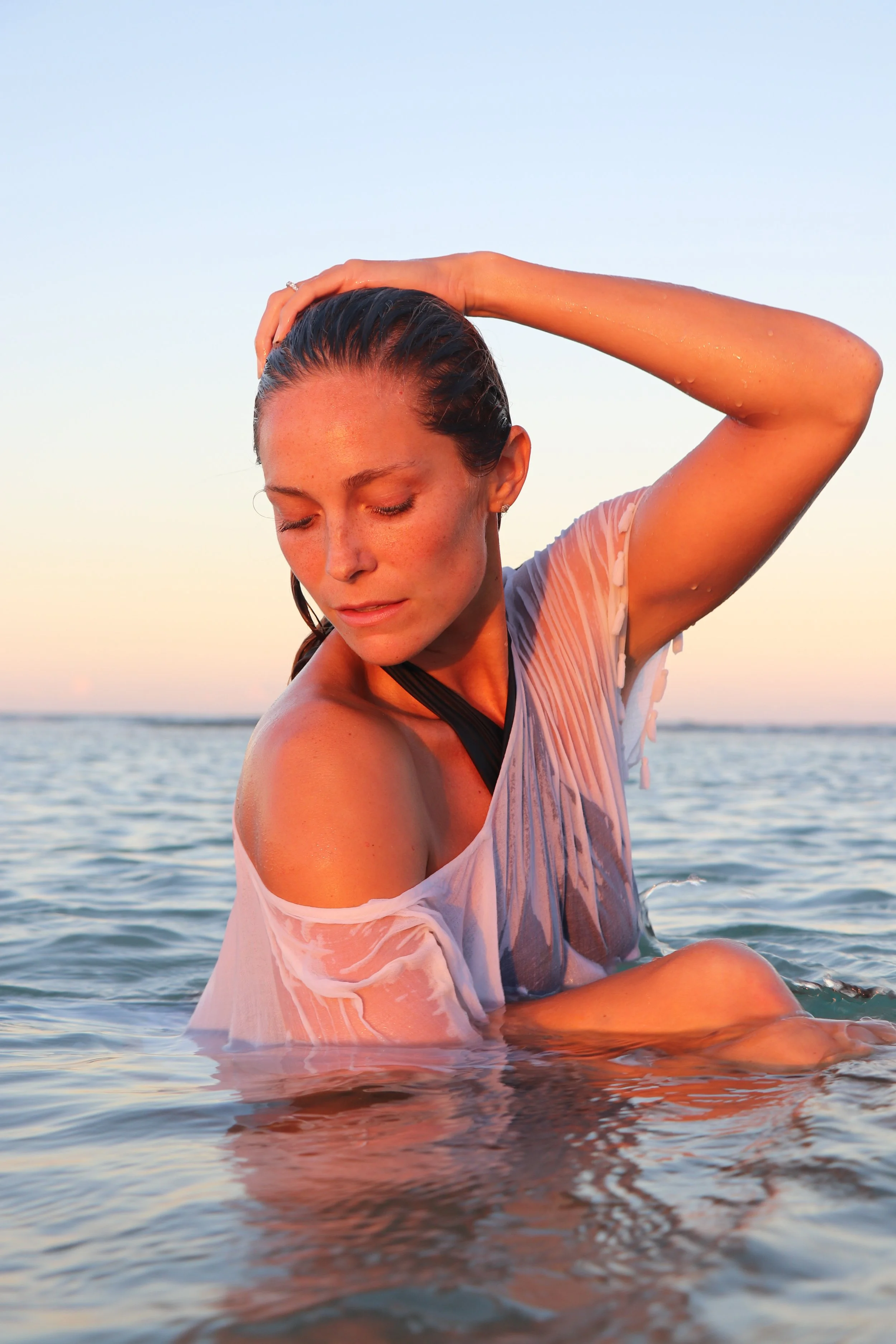 Beauty portrait of Megan Koval with wet hair in the ocean at sunset.