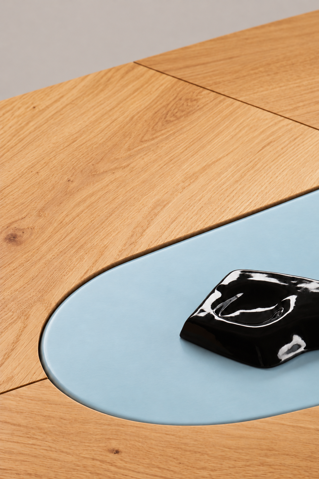 Glossy Black Sculpture on Blue Wood Inlay.png