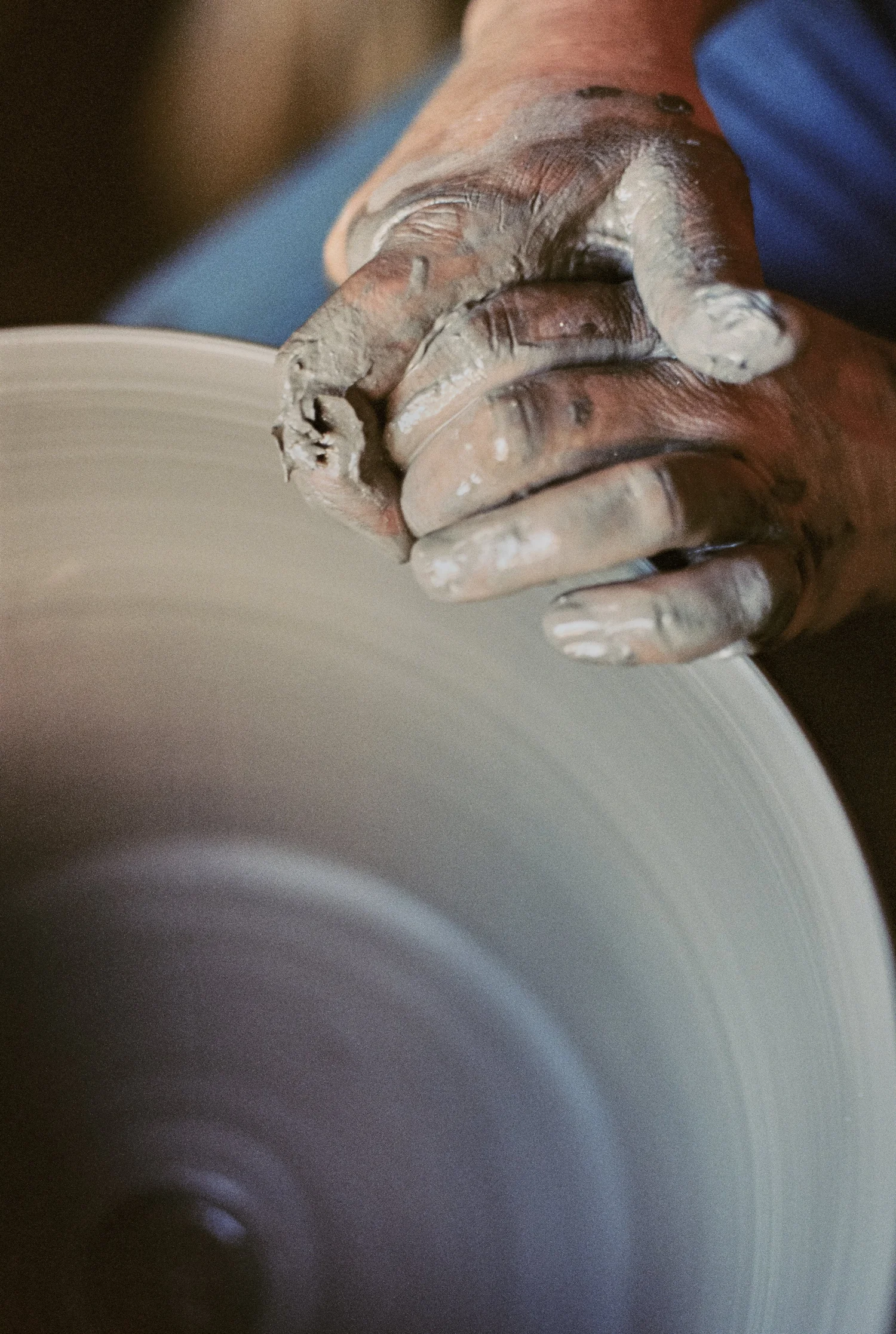 Hands shaping clay on the wheel