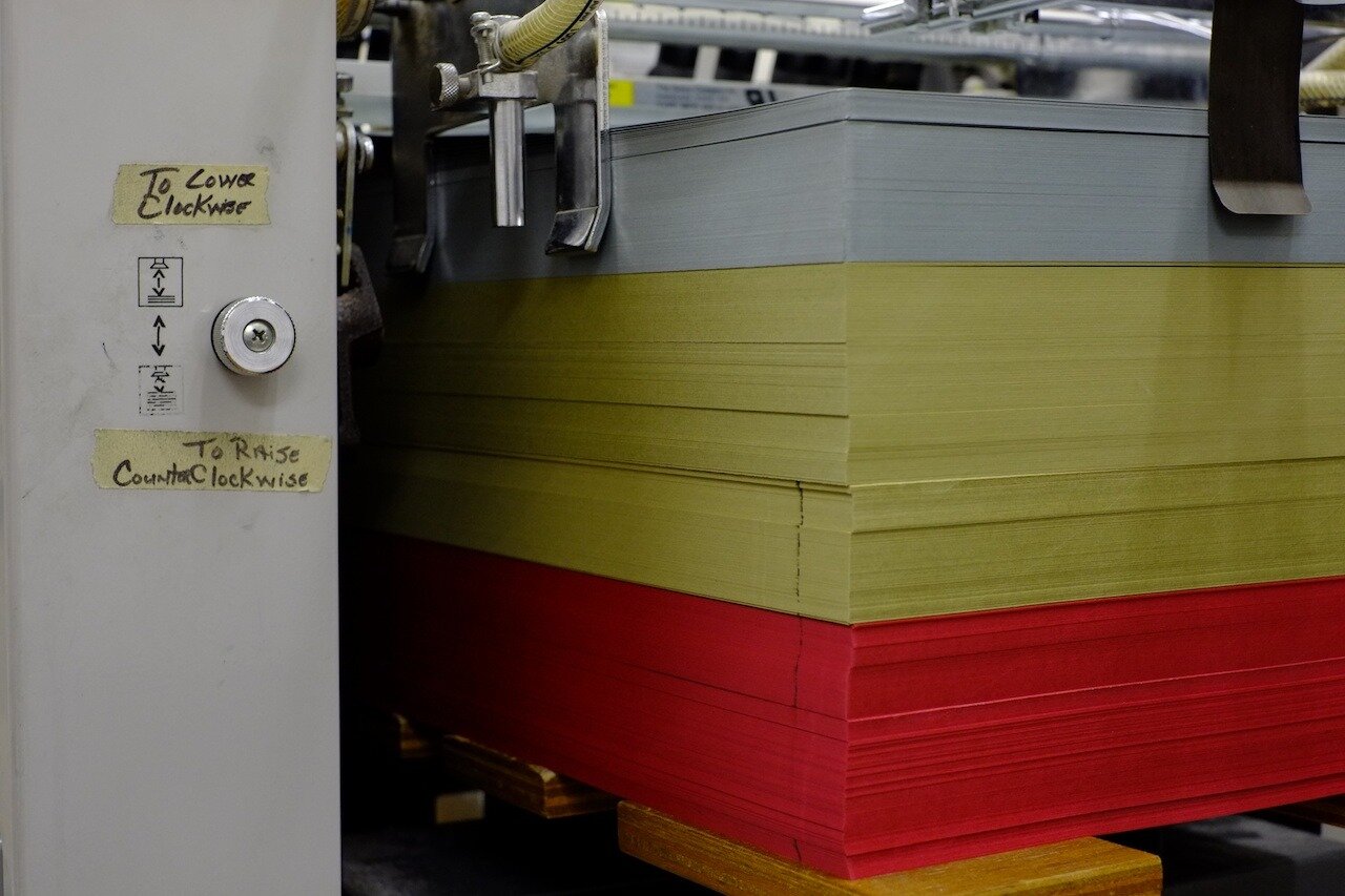 Paper stacked on press waiting to be printed on.
