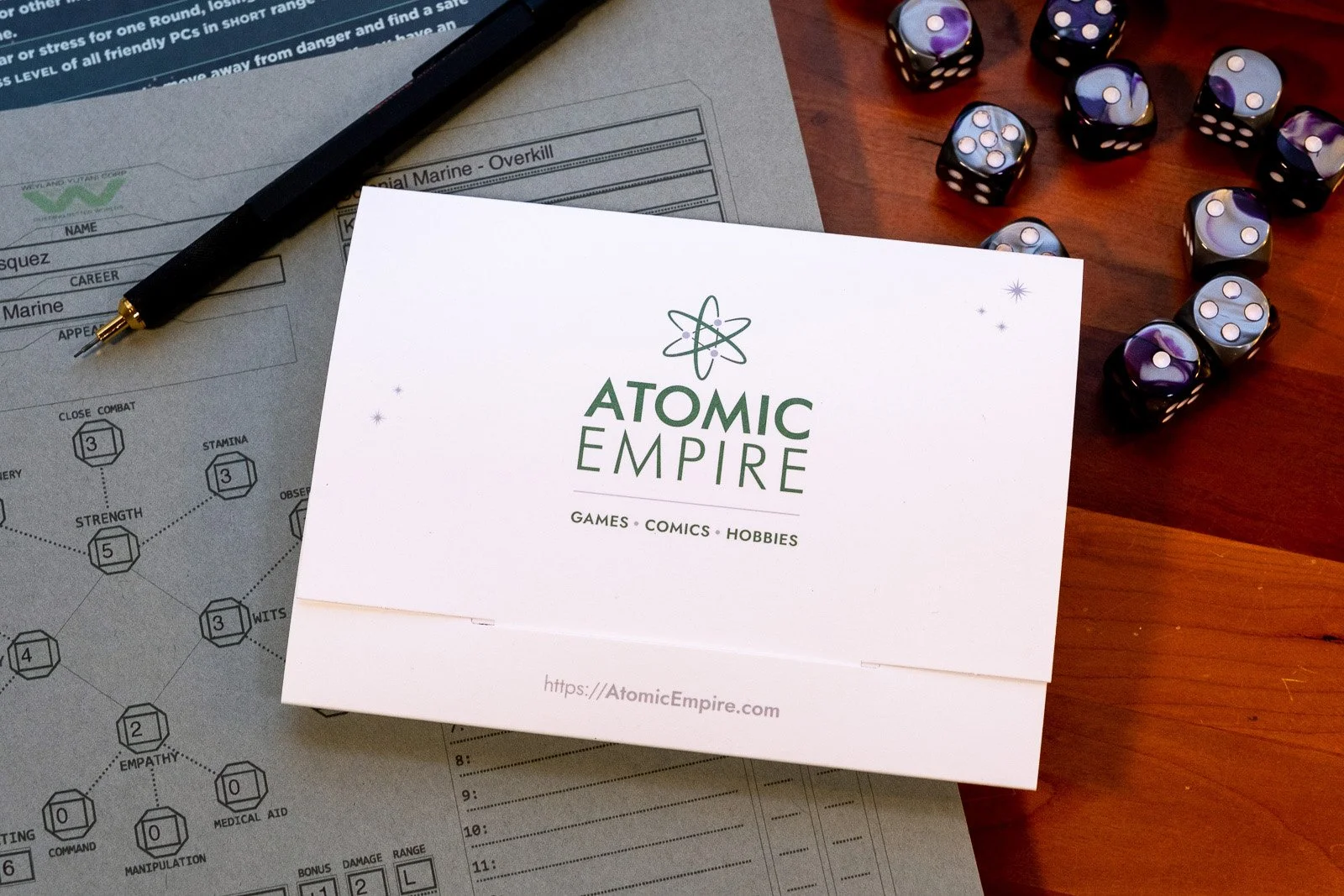 A gift card holder design for Atomic Empire, featuring a clean white background and green graphics.