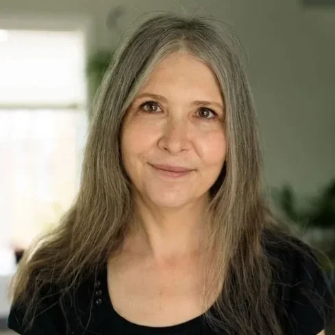Woman with shoulder length hair and kind eyes smiling