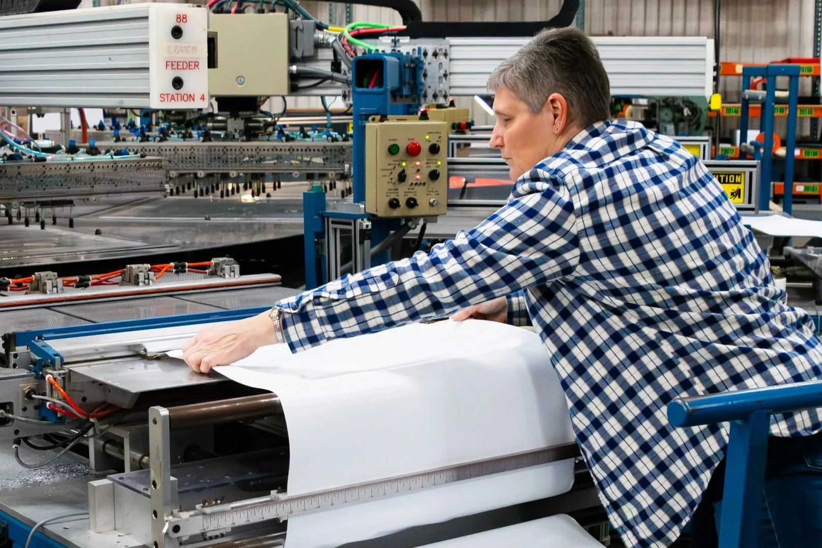 Employee loading a proprietary RF Heat Sealing machine in a casual environment.