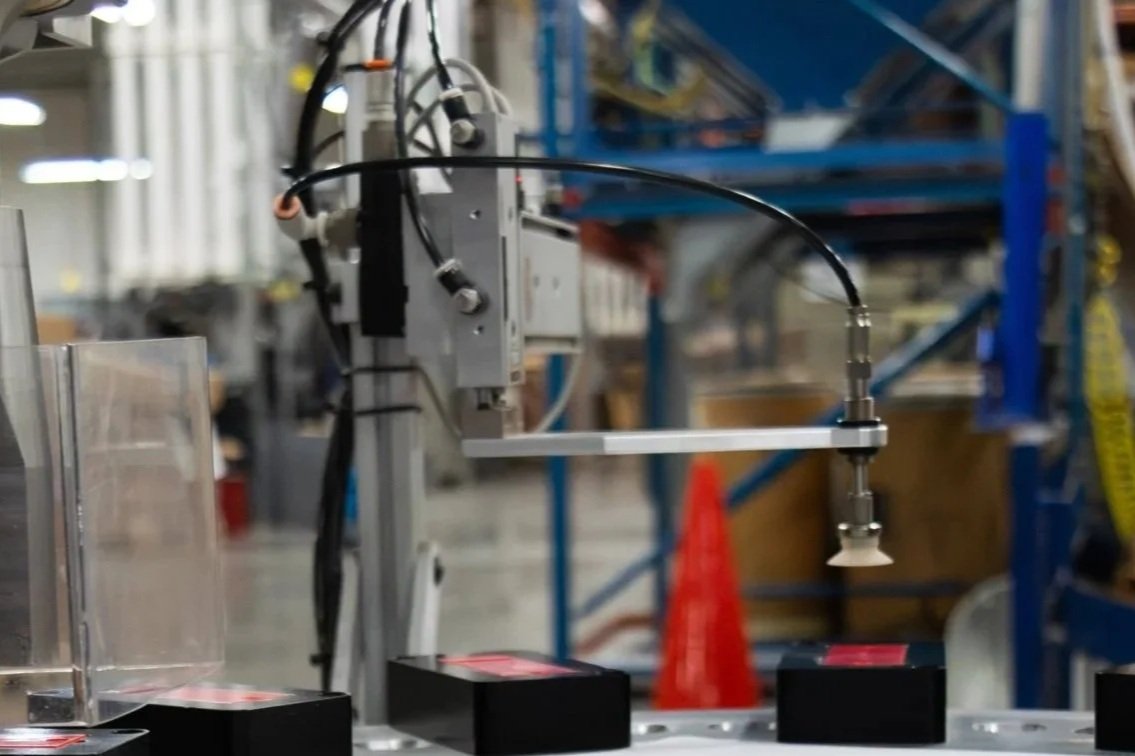 An image of a sonic welding machine finishing a bright red product.