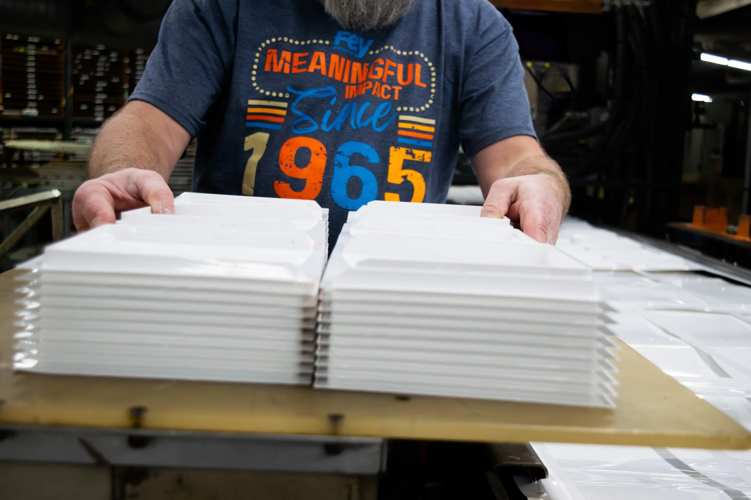 Image of a responsible employee handling clean thermoforming product.