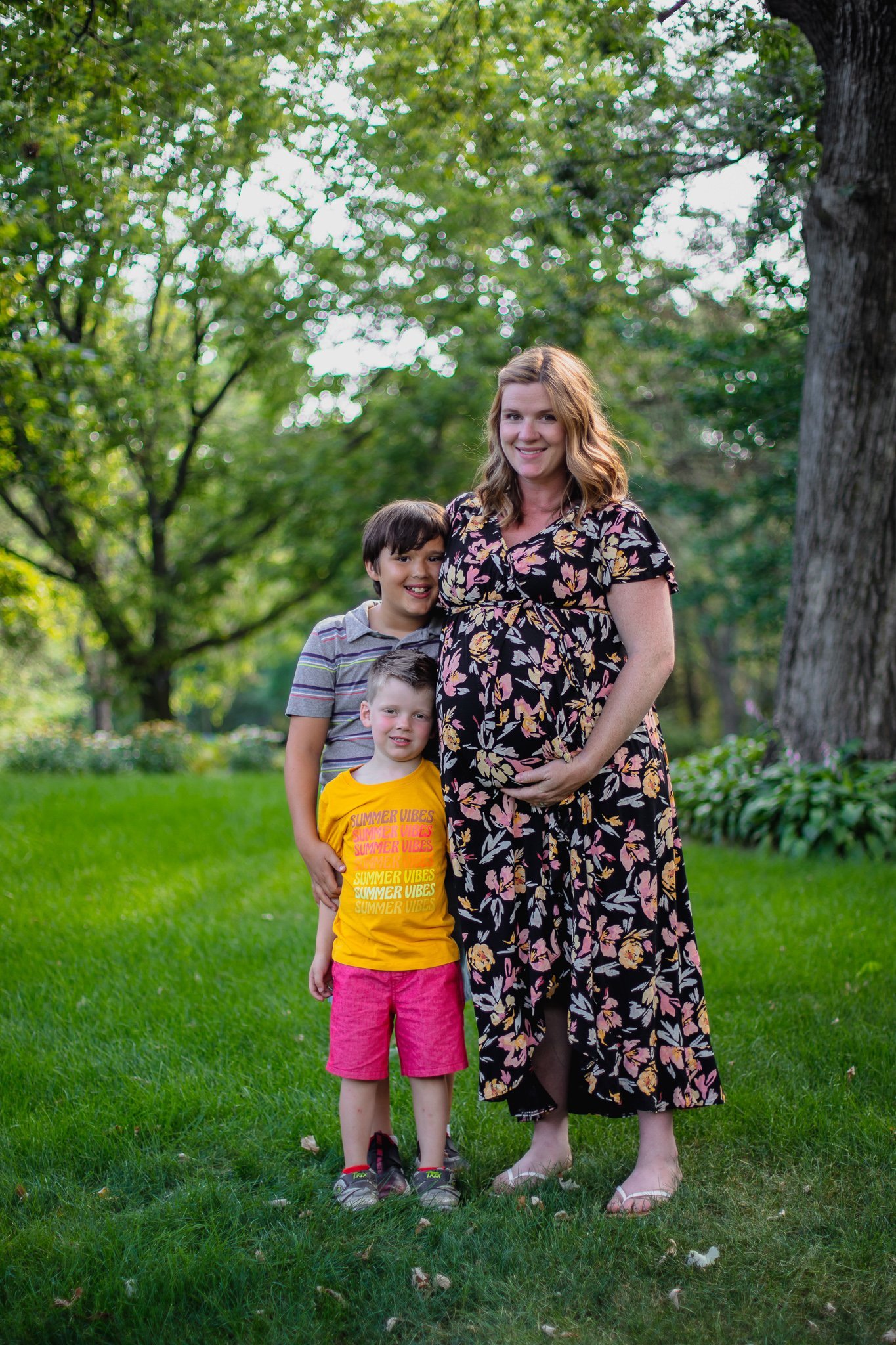 Maternity session, Mother holding baby bump standing next to her two sons