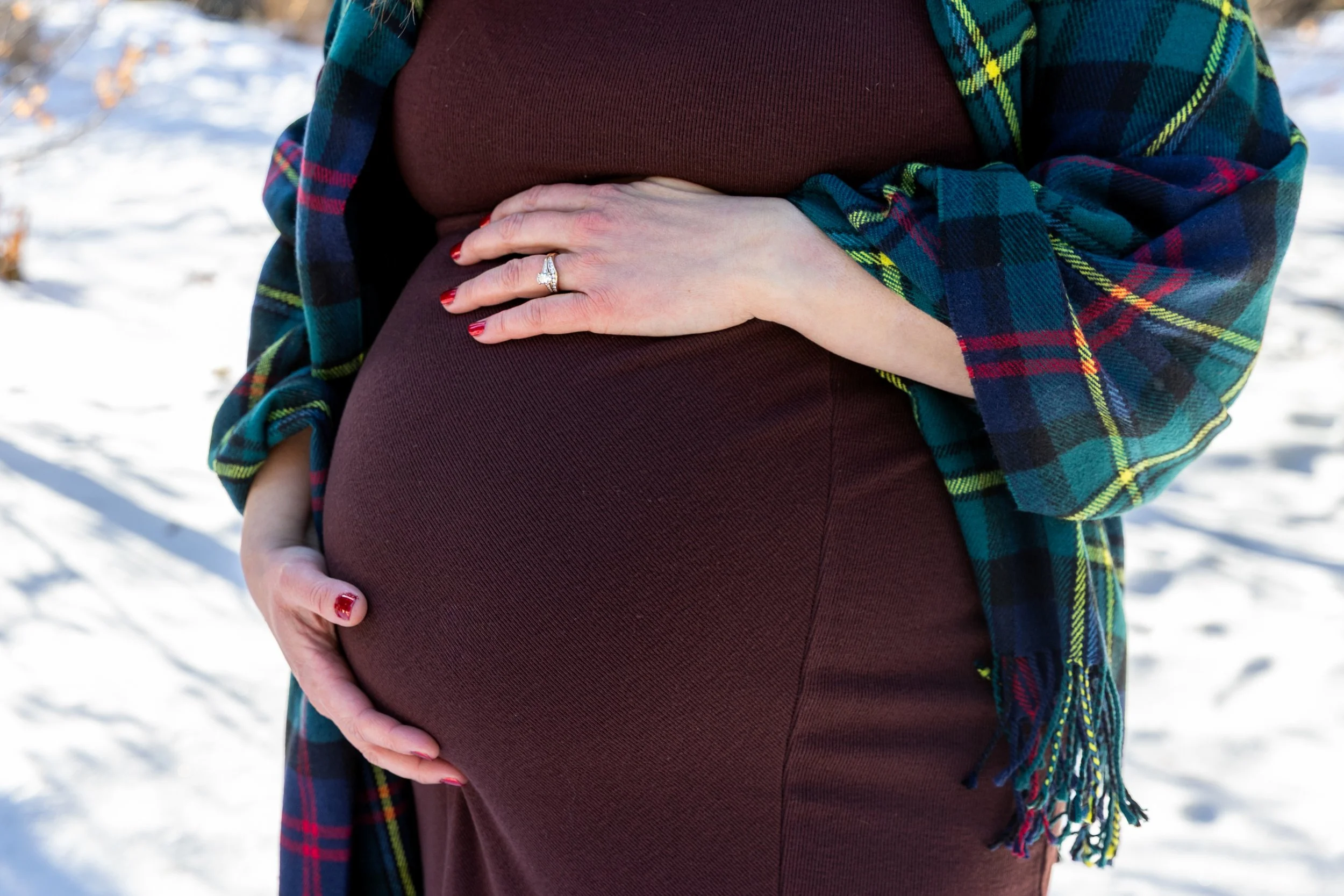Minneapolis maternity photography session - close up mother standing together cradling her baby bump while at Arneson Acres Park in Edina, MN in the winter.
