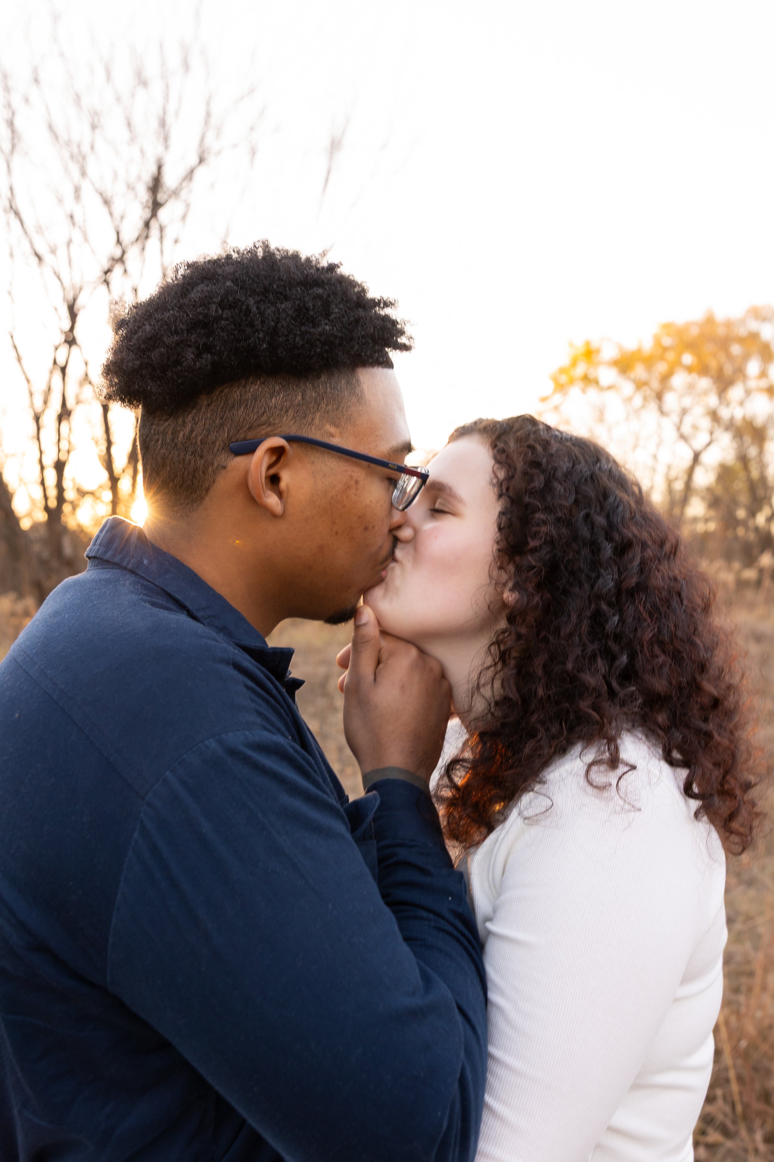 Minneapolis couples photography - A couple embrace each other and are kissing at Minnehaha Falls Park in Minneapolis, MN.