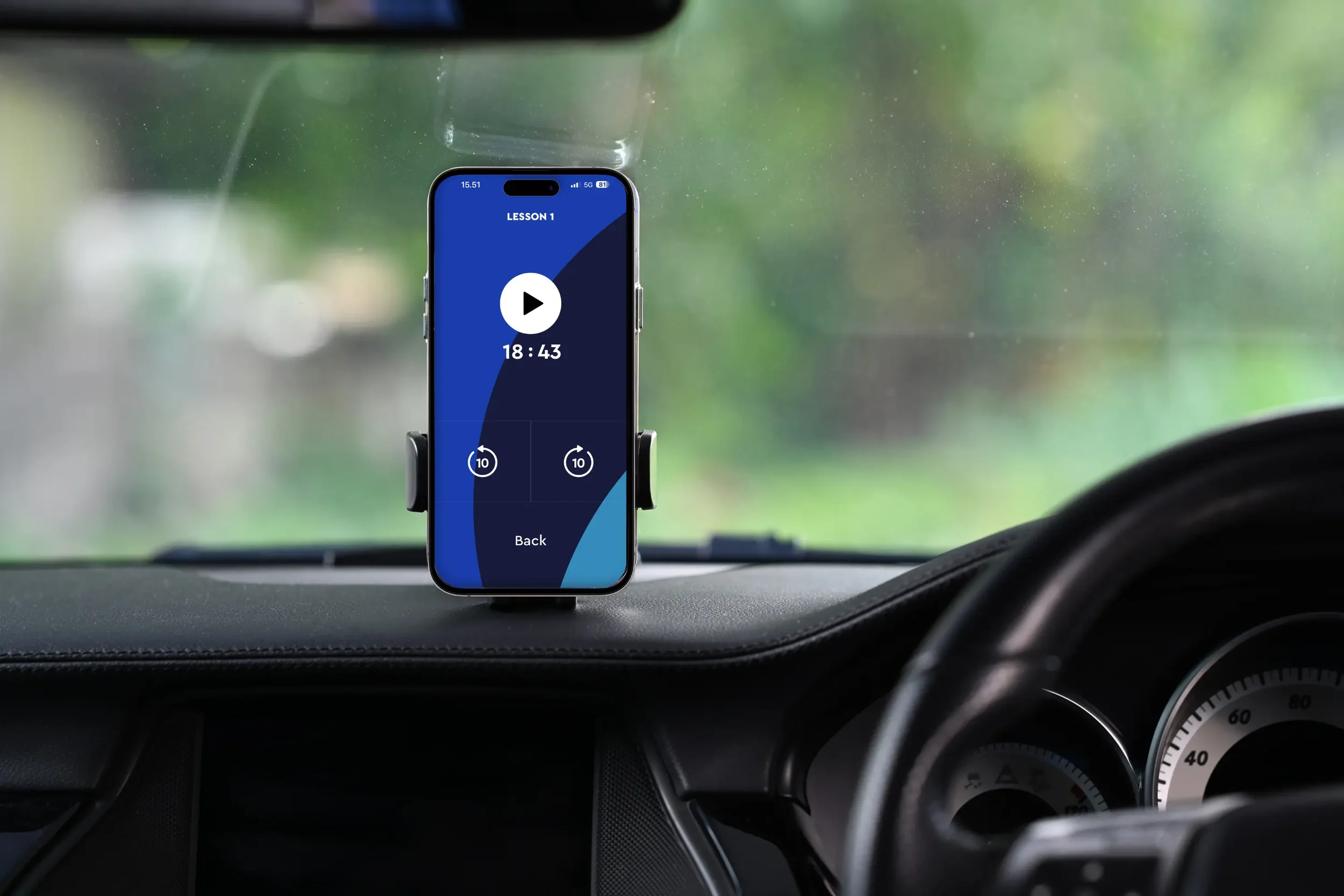 A phone mounted on a car dashboard showing Pimsleur's driving mode mid-lesson, illustrating how you can do audio lessons hands-free while driving.