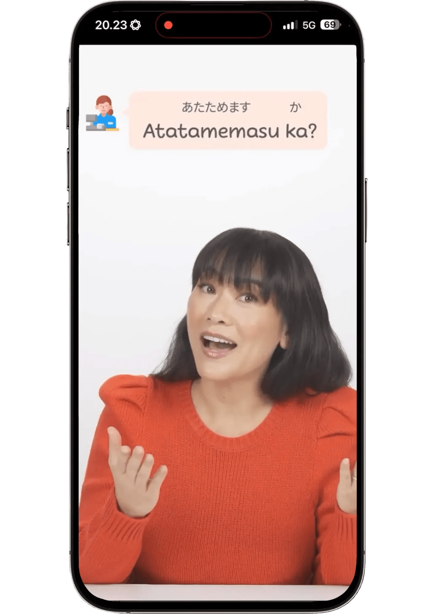 Speak app screen showing a Japanese teacher with a speech bubble reading "Atatamemasu ka? Do you want it heated?" — the convenience store phrase learners recognize rather than say