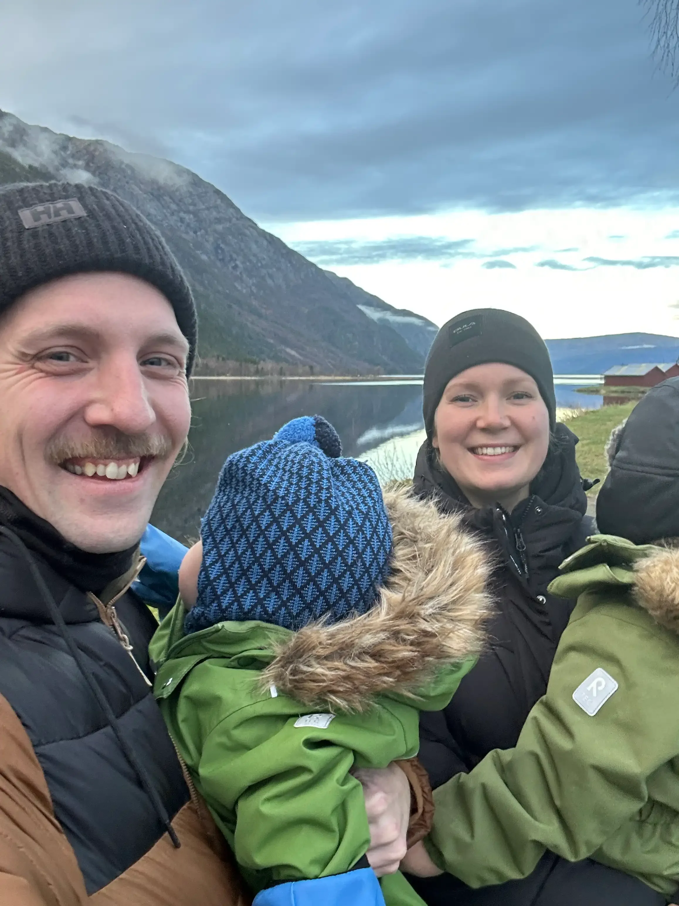 Christian Tapper with his wife and two young sons by a fjord in Norway on a winter day.