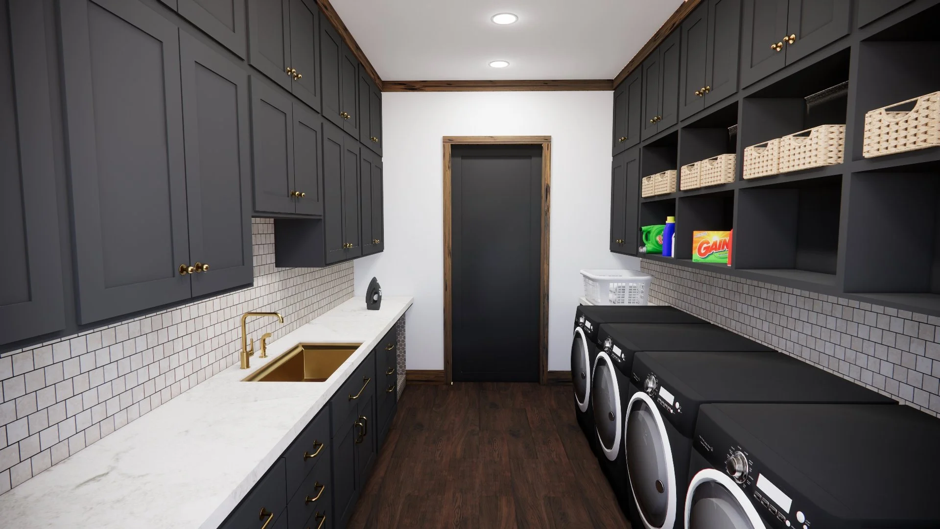A modern laundry room with dark cabinets, white subway tile backsplash, a gold sink and faucet, and a washer and dryer. Open shelving with baskets and laundry supplies. Dark wooden floor and a black door at the back.
