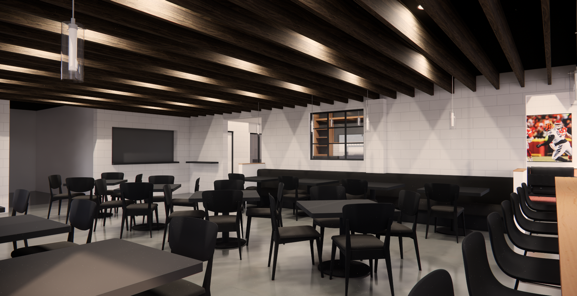 Modern dining or meeting area with black chairs and tables, white brick walls, and a dark wood ceiling with hanging lights; a large screen is mounted on the wall and a sports poster is visible on the right.