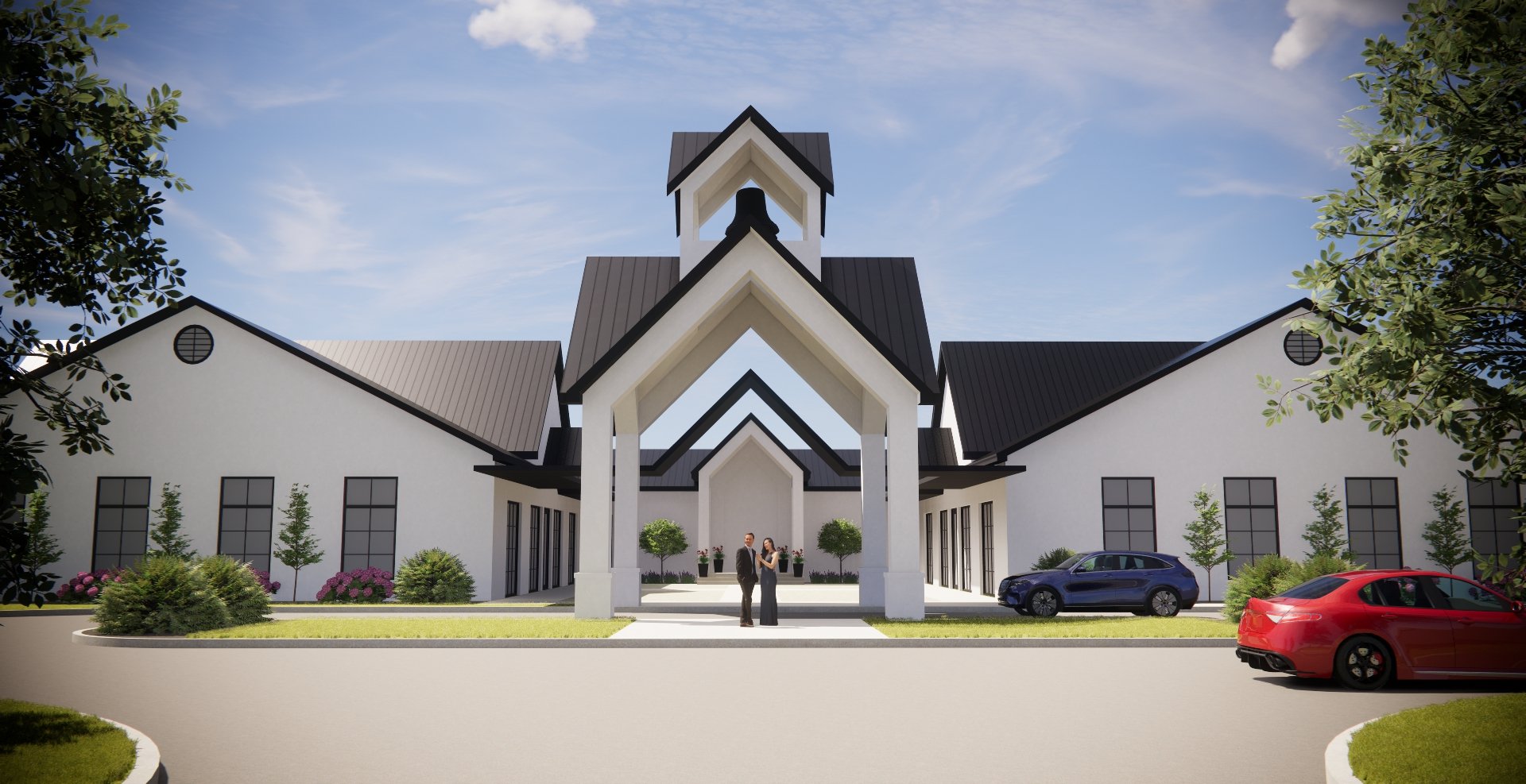 Modern white building with black roof accents, large windows, and a central entrance with two people standing in front, surrounded by landscaped greenery and cars parked along the driveway under a blue sky.