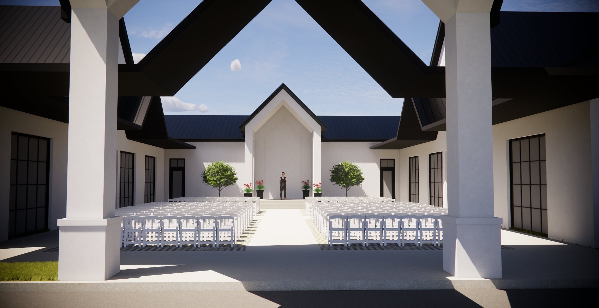 Outdoor wedding ceremony setup with white chairs, two trees in planters, and a person in formal attire standing at the altar under a modern white pavilion with a peaked roof, against a blue sky with clouds.