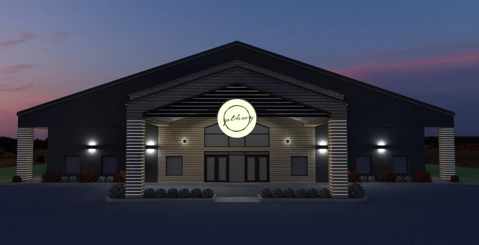 Modern building with a steep roof, illuminated signage reading 'pathway', and exterior lighting at dusk.
