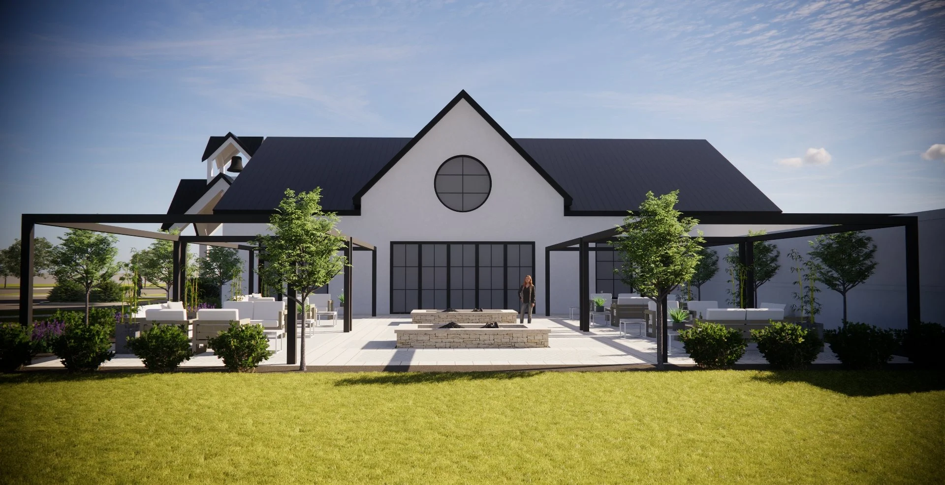 Modern white house with a dark roof, circular window, and outdoor patio area featuring trees, white chairs, and a fire pit under a clear blue sky.