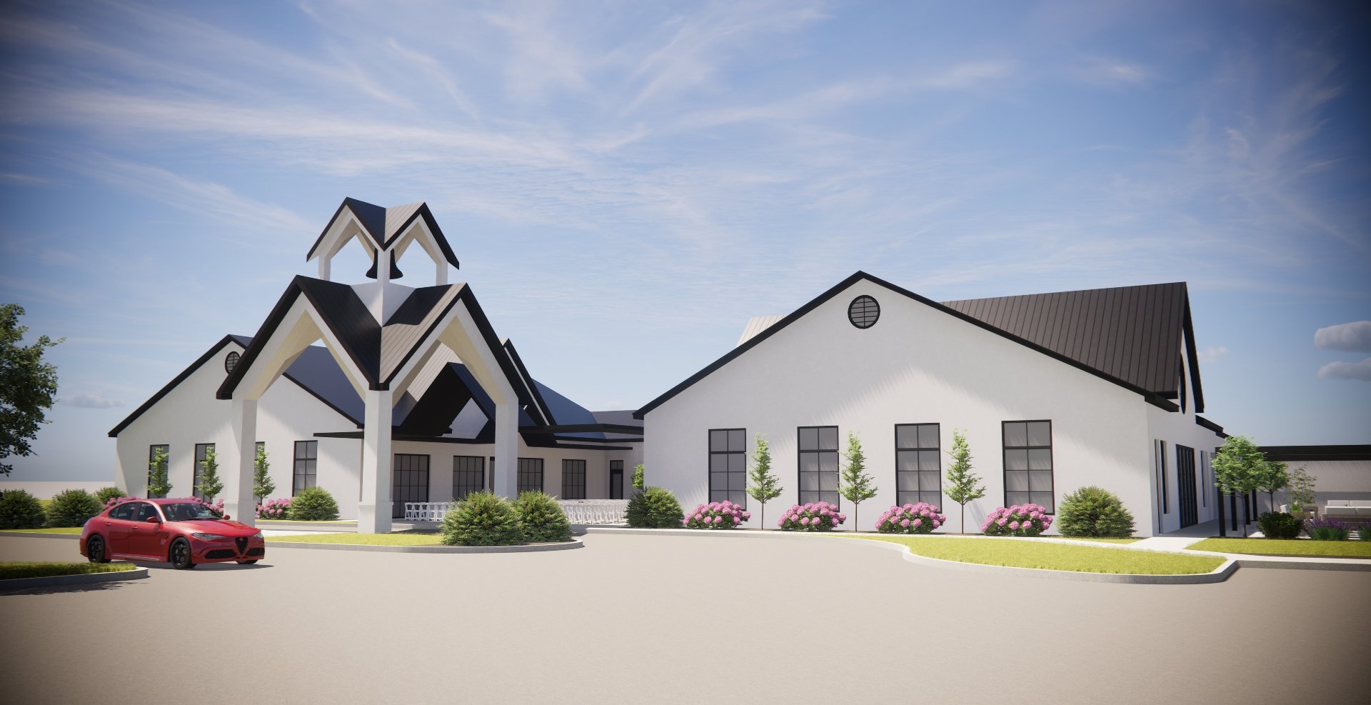A modern church with a white exterior and black roofing, featuring tall windows, surrounded by landscaping with bushes, flowers, and small trees under a blue sky with few clouds, and a red car parked nearby.