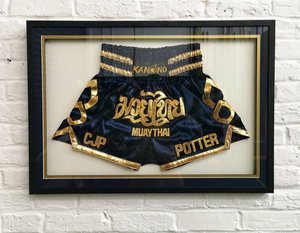 Muay Thai shorts in a custom frame with gold insert.