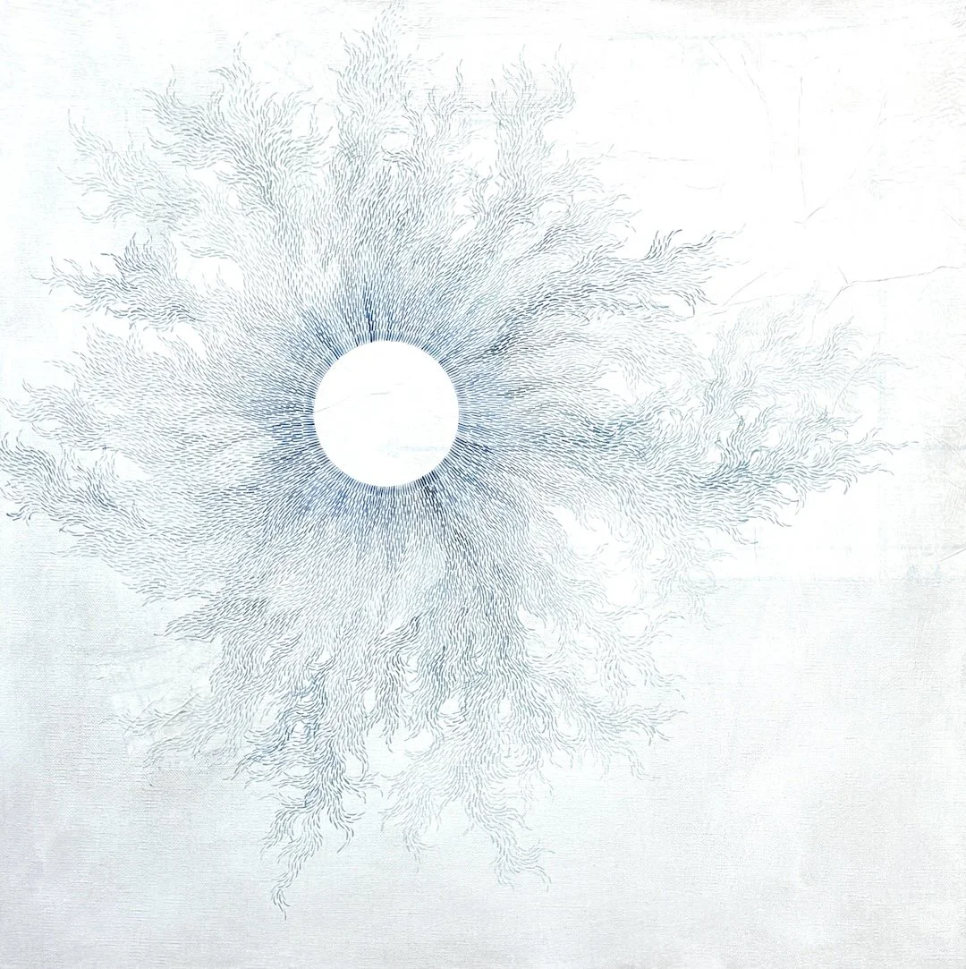 A white surface with a circular pattern of thin, blue lines radiating outward from a central white circle, resembling a detailed map or intricate design.