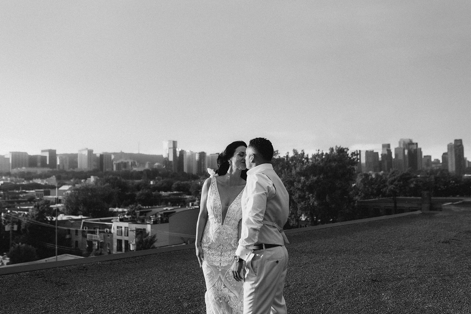 Couple sur le toit d'un building avec vue sur le centre ville de Montréal au couché du soleil.
