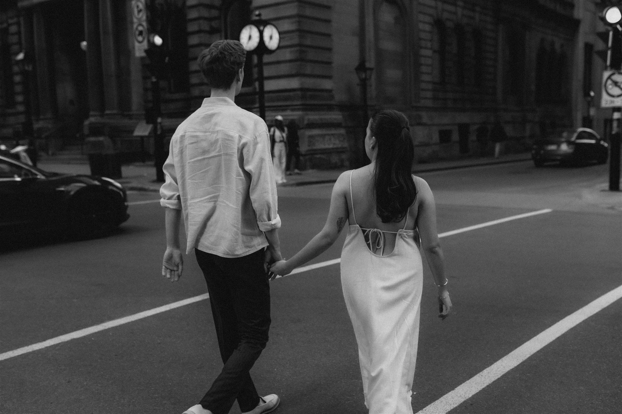 Couple walking hand in hand through the streets of Montreal's Old Port.